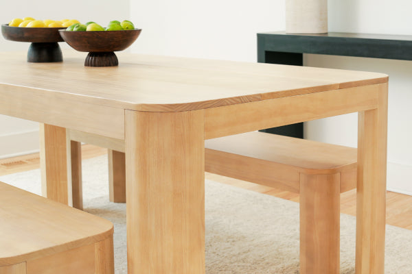 Light oak solid wood dining table with benches and fruit bowl centerpiece in minimalist dining room