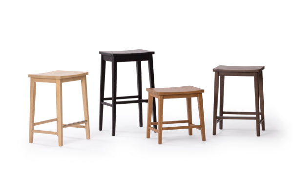 Set of four wooden stools in varying heights and finishes (light wood, medium oak, walnut, dark brown) with square seats and minimalist modern design on white background