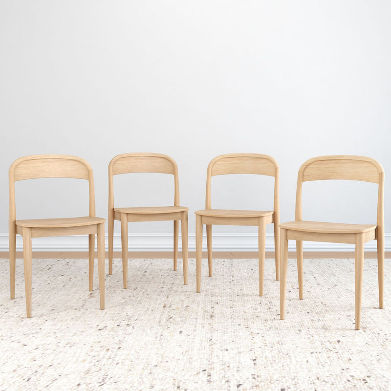 Set of four light natural wood dining chairs with curved backs on a textured neutral rug against a white wall, minimalist Scandinavian style.