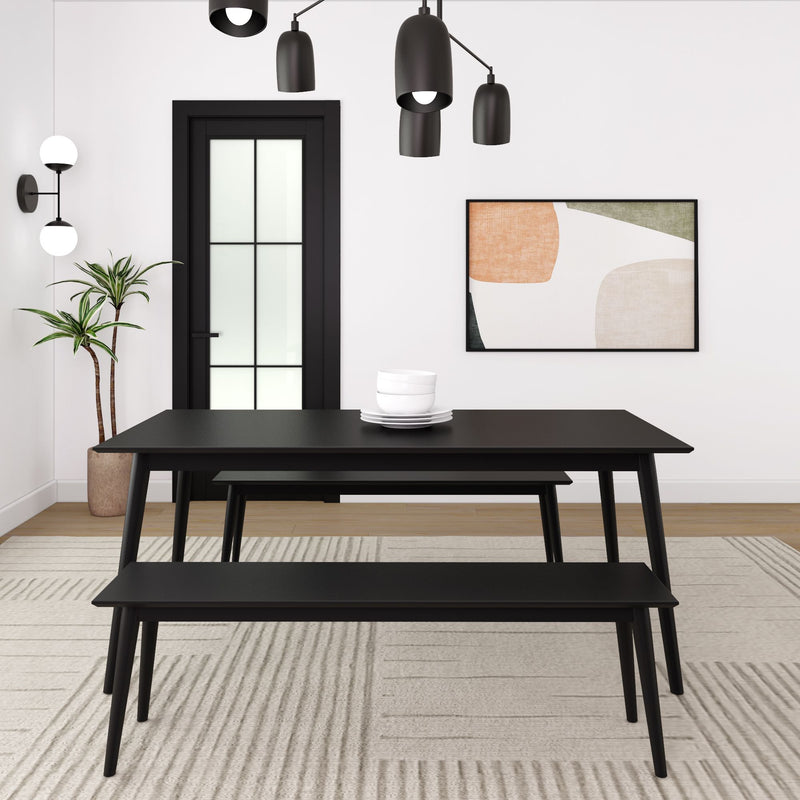 Modern black dining table with matching bench in minimalist room décor.