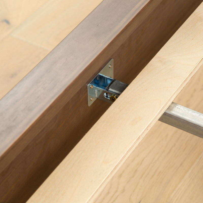 Close-up of a wooden furniture joint with metal bracket support for stability.