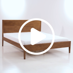 Minimalist wooden bed frame with a modern design and white mattress in a bright room.