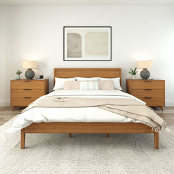 Modern minimalist bedroom with wooden bed frame, matching nightstands, and cozy decor accents.