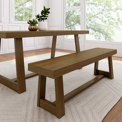 Modern farmhouse oak dining table and bench with succulent centerpiece by large sunlit windows in a bright minimalist dining room