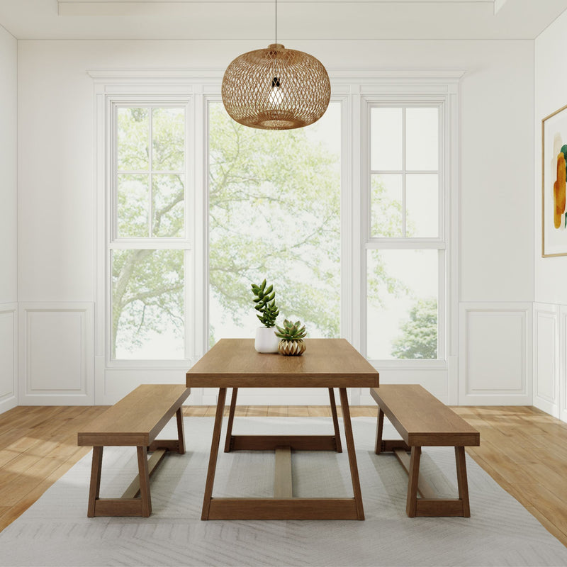 Minimalist dining room with wooden table, matching benches, wicker pendant light, and natural light from large windows.