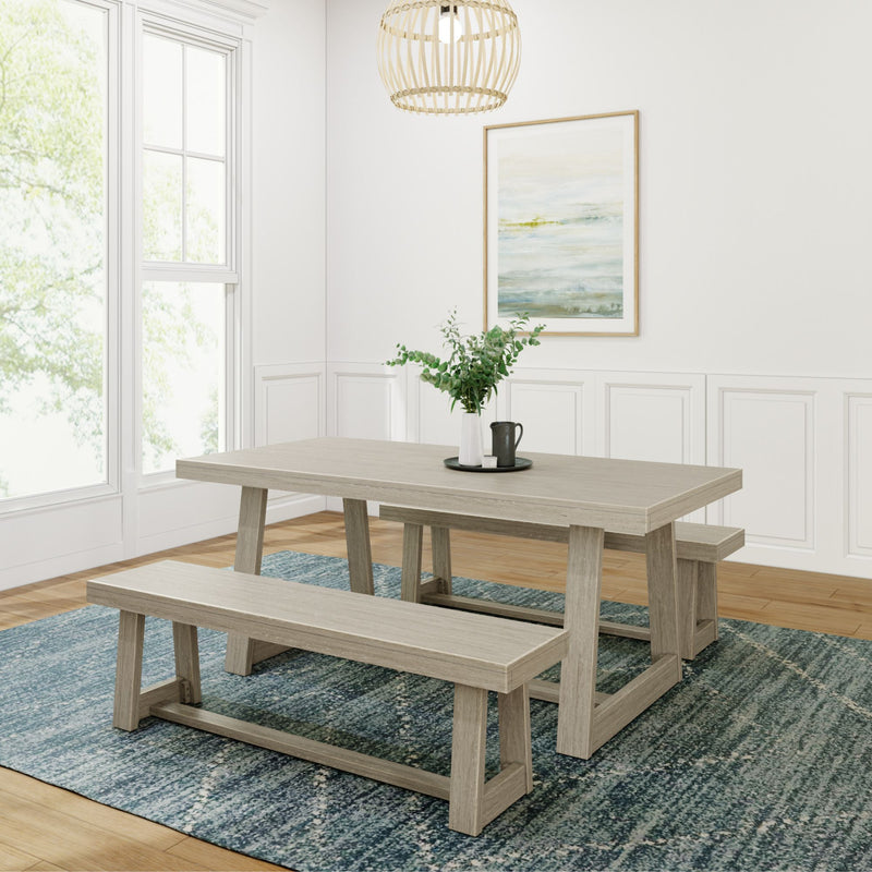 Modern dining room with wooden table and benches, blue rug, and wall art in bright, minimalist home.