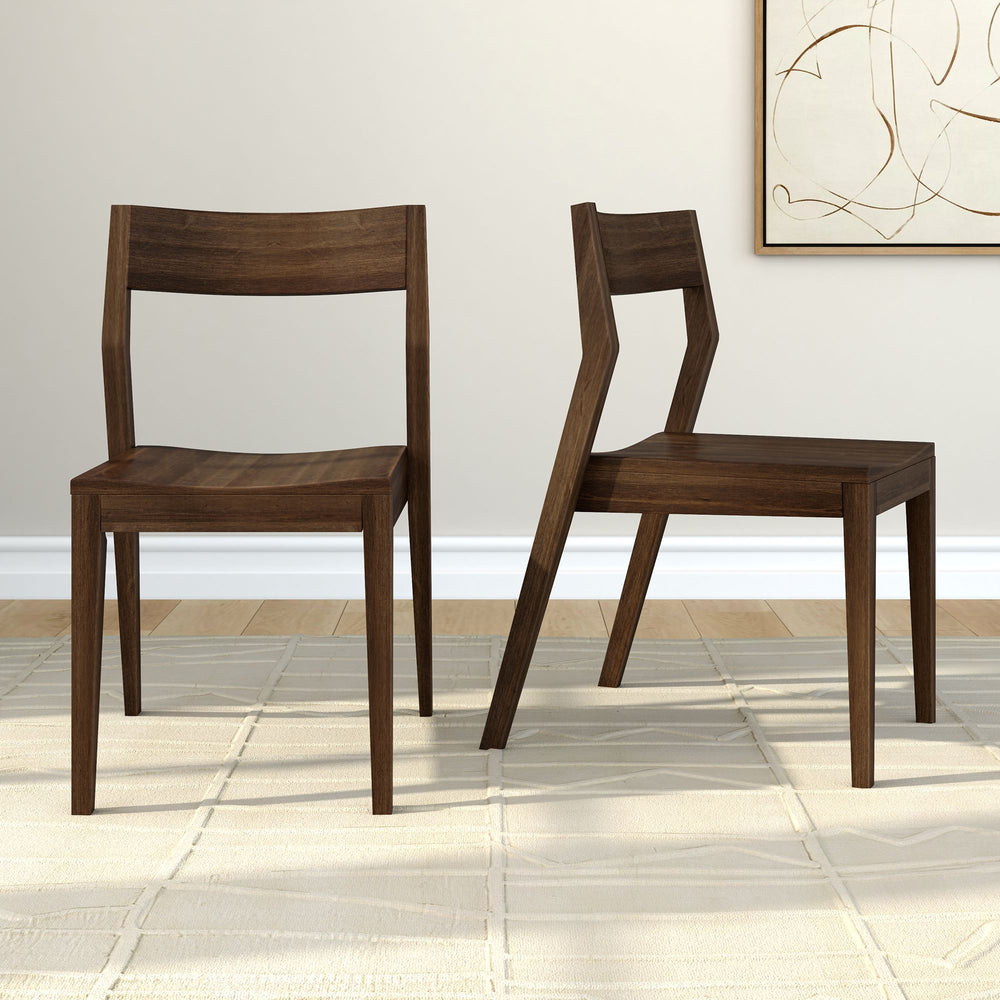 Two modern wooden chairs with unique angular design on a light beige rug in a minimalist home interior.
