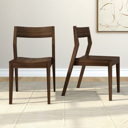 Two modern wooden chairs with unique angular design on a light beige rug in a minimalist home interior.
