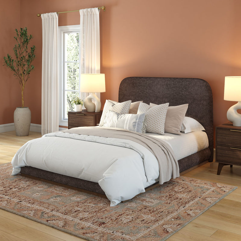Elegant bedroom with a dark upholstered bed, white bedding, and earth-toned decor.