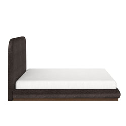 Modern upholstered bed with a white mattress on a sleek wooden frame, side view.