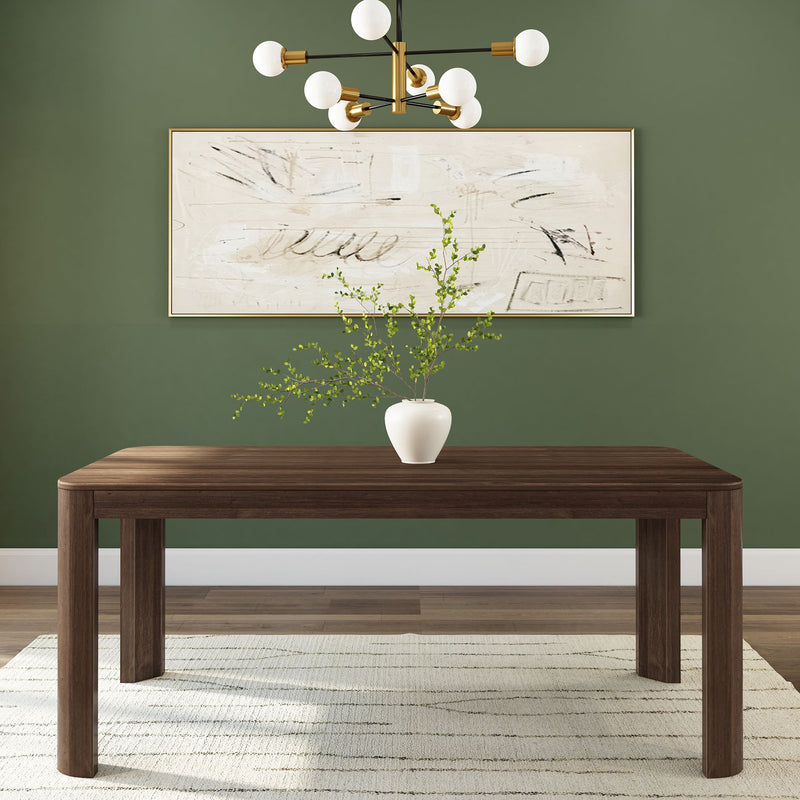 Modern dining room with wooden table, green walls, abstract wall art, and white vase with greenery.
