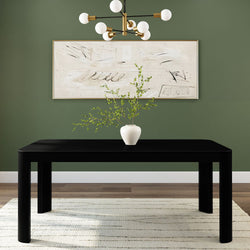 Modern dining room with a black table, green wall, abstract art, and a white vase centerpiece.