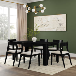 Modern dining room with black table, matching chairs, abstract art, and green walls.