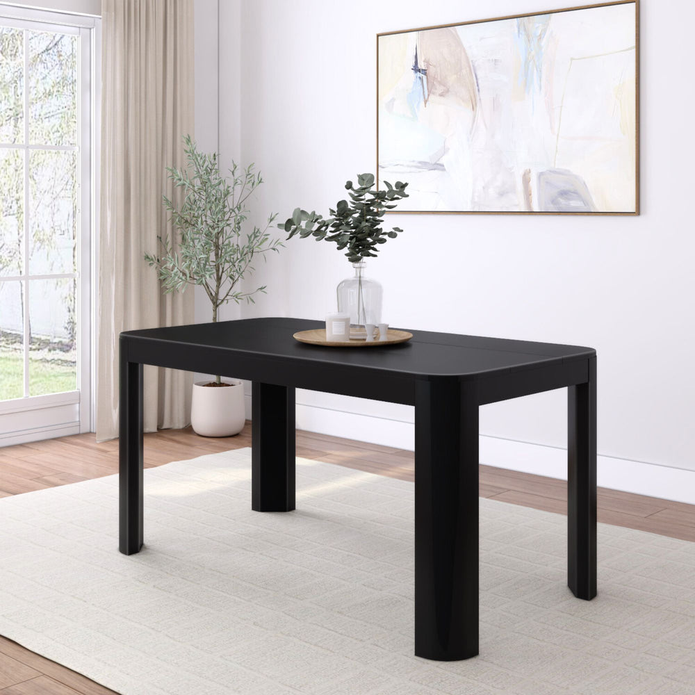 Modern black dining table in a bright, minimalist living room with white walls and large window.