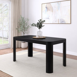 Modern black dining table in a bright, minimalist living room with white walls and large window.