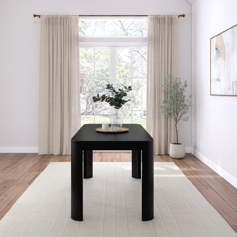 Modern dining room interior with black table, minimalist decor, and large window for natural light.