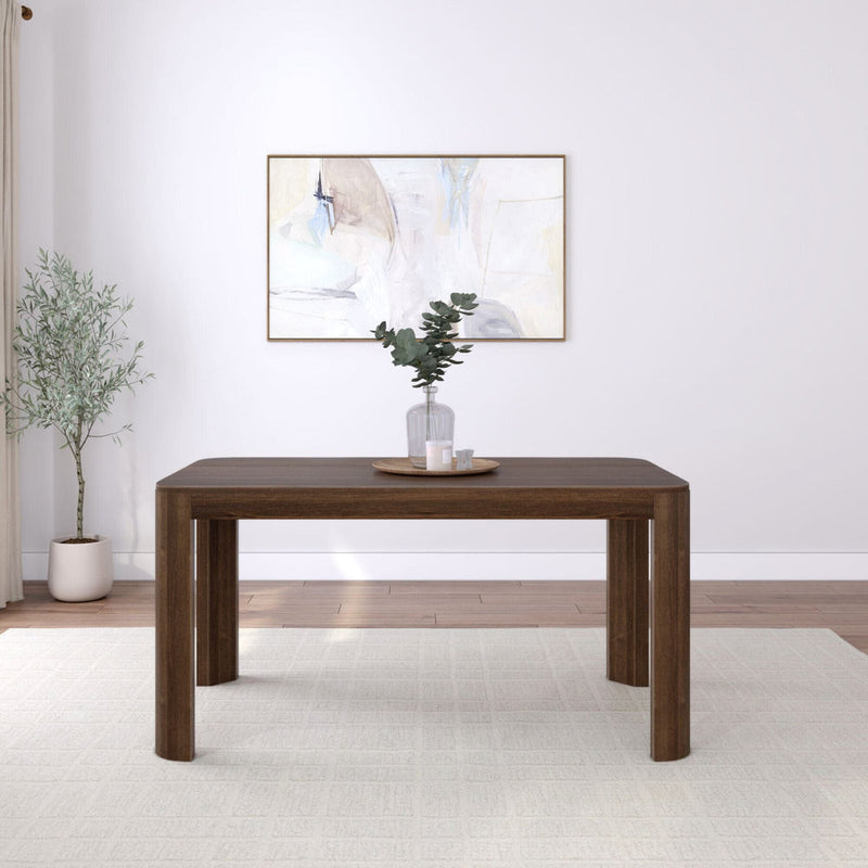 Mid-century modern dark wood dining table in a minimalist living room with abstract wall art and greenery.