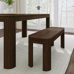 Dark walnut dining table and bench in modern farmhouse dining room with French doors, sheer curtains, hardwood floor and glass vase on tray
