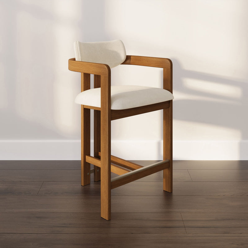 Modern wooden bar stool with cream upholstered seat and curved backrest, minimalist mid-century design on dark hardwood floor against a neutral wall, ideal kitchen island seating
