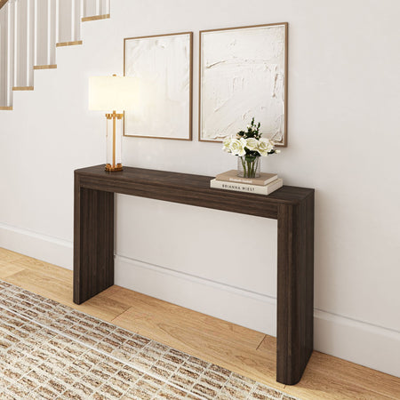 Modern dark wood console table in hallway with decorative lamp, art pieces, and flower vase.