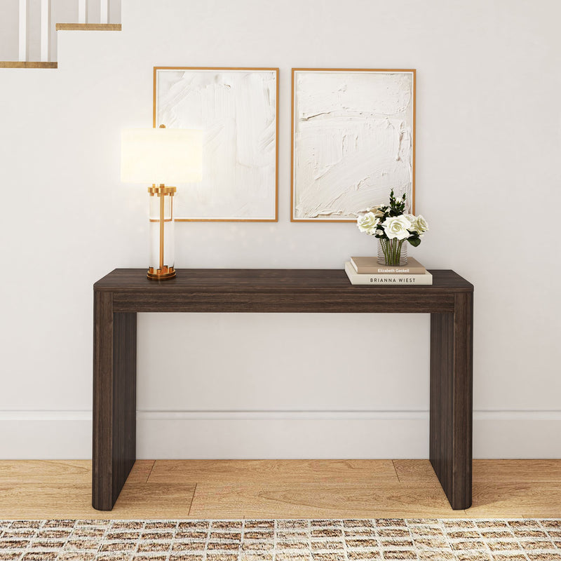 Minimalist entryway with dark wood console table, modern lamp, and abstract wall art.
