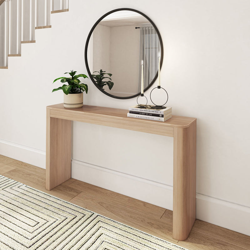 Modern minimalist entryway decor with wooden console table, round mirror, and stylish plant arrangement.