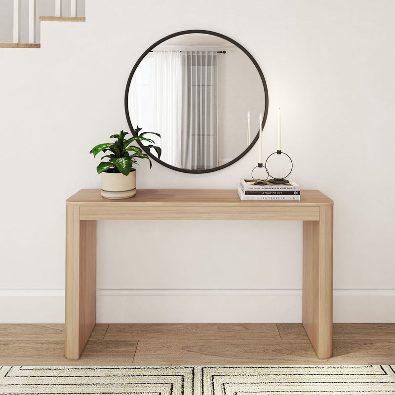 Minimalist room with wooden console table, round mirror, potted plant, and candle holder for modern home decor.