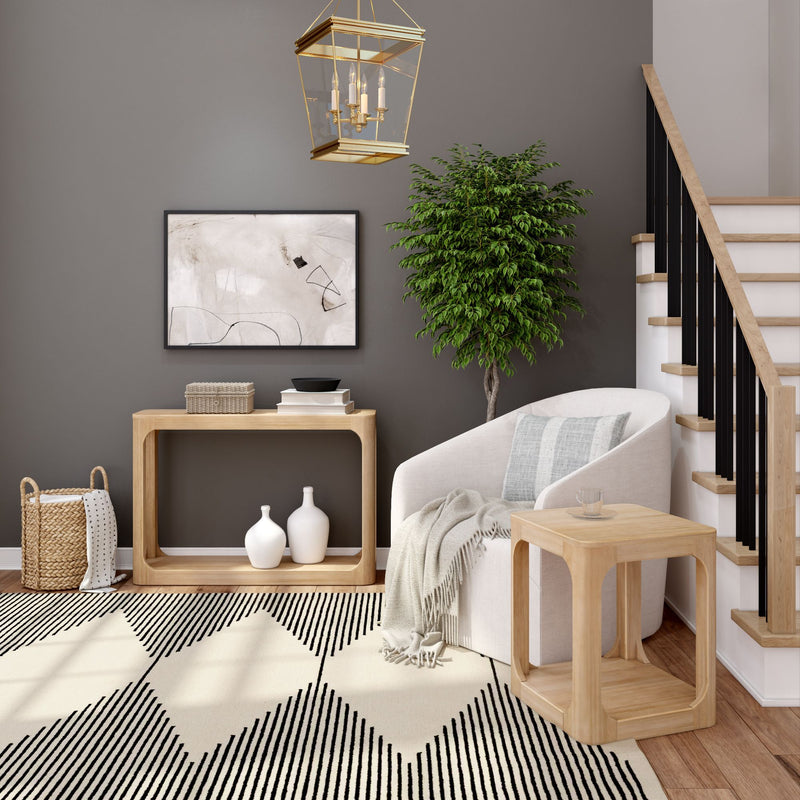 Modern living room interior featuring stylish staircase, cozy armchair, elegant wooden furniture, decorative plants, and contemporary art on a neutral wall.