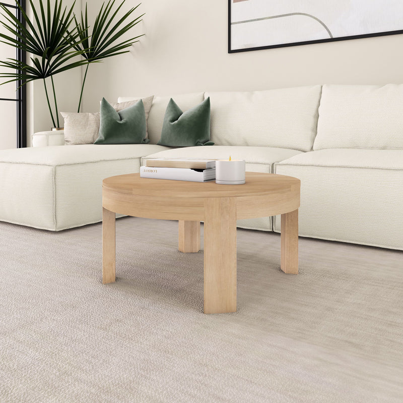 Modern living room with a white sectional sofa, round wooden coffee table, and decorative pillows.