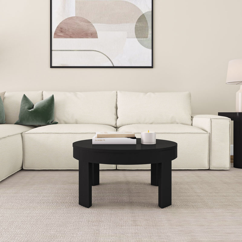 Modern living room with white sofa, black coffee table, abstract wall art, and green cushions.