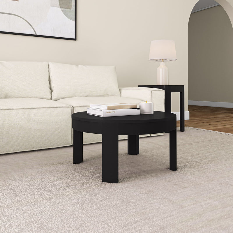 Modern living room with black coffee table, white sofa, and lamp on side table.