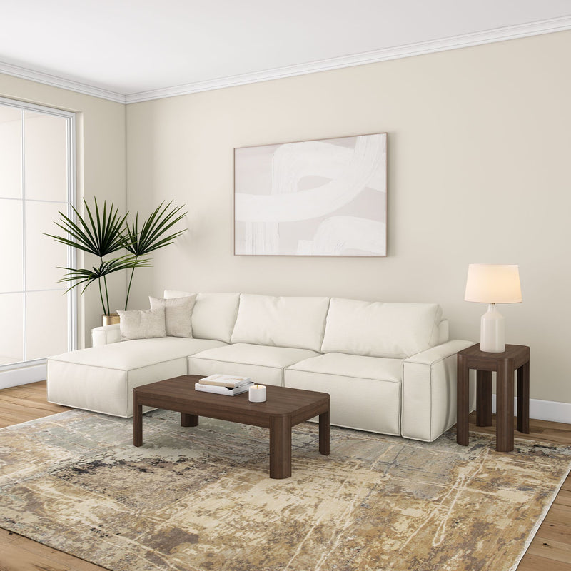 Stylish modern living room with white sectional sofa, abstract wall art, and wooden coffee table on a patterned rug.