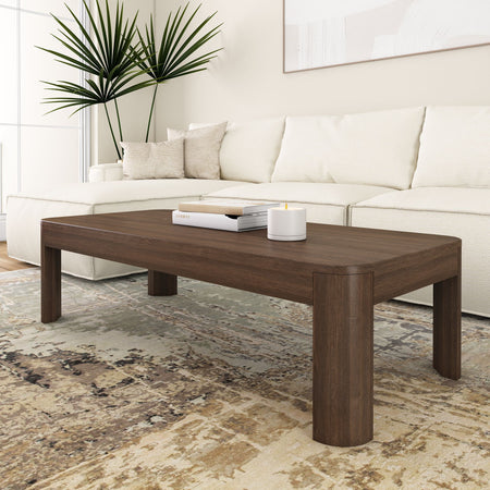 Modern living room with a wooden coffee table, white sectional sofa, and decorative plants.