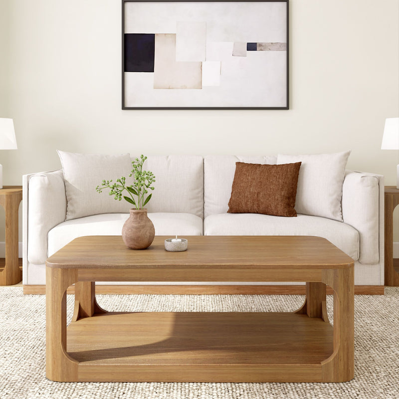 Modern living room with a minimalist design featuring a wooden coffee table, white sofa, abstract wall art, and decorative plants.