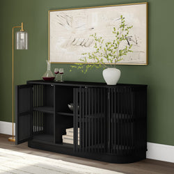 Contemporary black sideboard with open shelves, white vase, and wine glasses against a green wall backdrop.