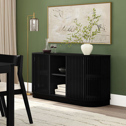Modern black sideboard with decorative vase and wine glasses against green wall in elegant dining room.