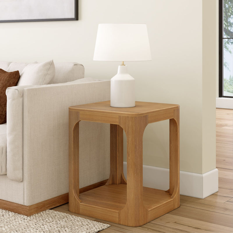 Modern living room with beige sofa, wooden side table, and white lamp.