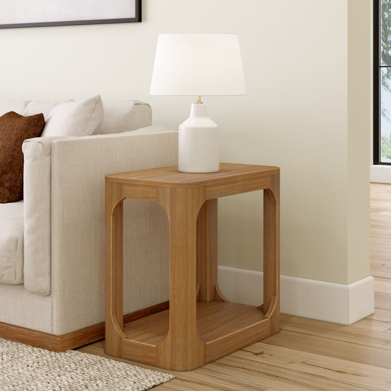 Modern living room with a stylish wooden side table and white lamp next to a beige sofa.