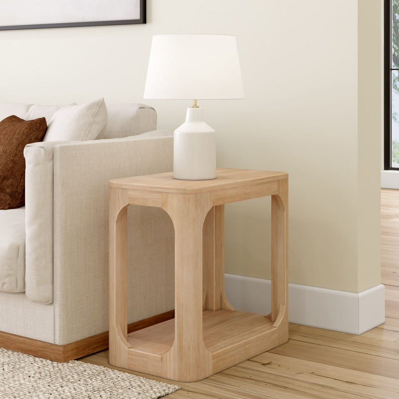 Modern living room with wooden side table and white lamp beside beige sofa.