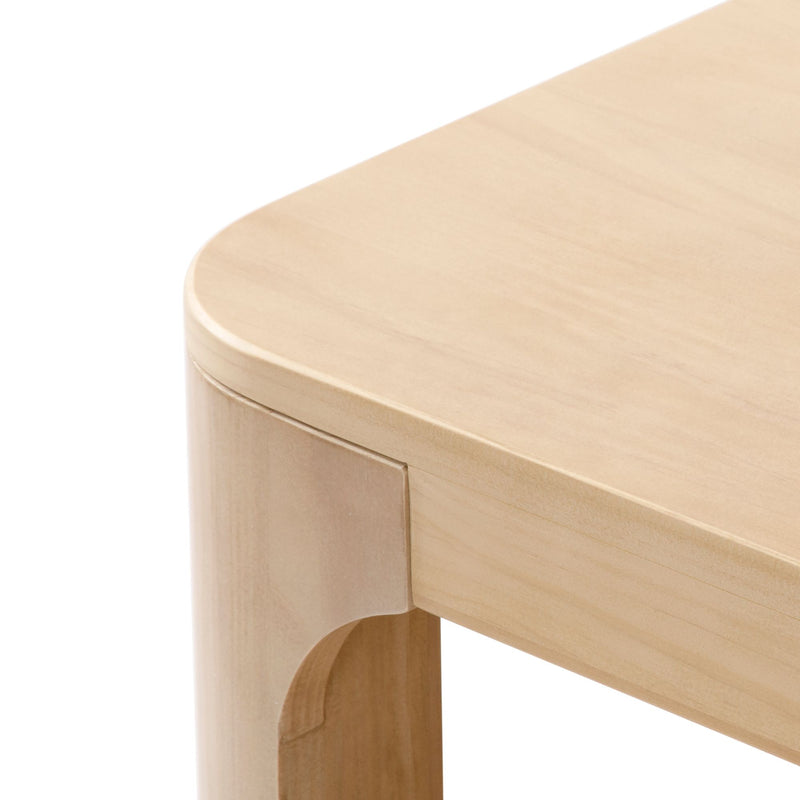 Modern natural wood table corner with rounded edges and smooth finish.