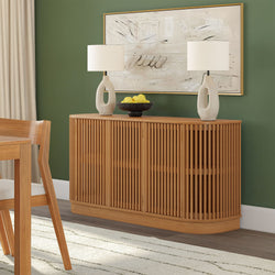 Mid-century modern slatted oak sideboard in dining room with green accent wall, two ceramic table lamps, framed abstract art and decorative bowl of lemons