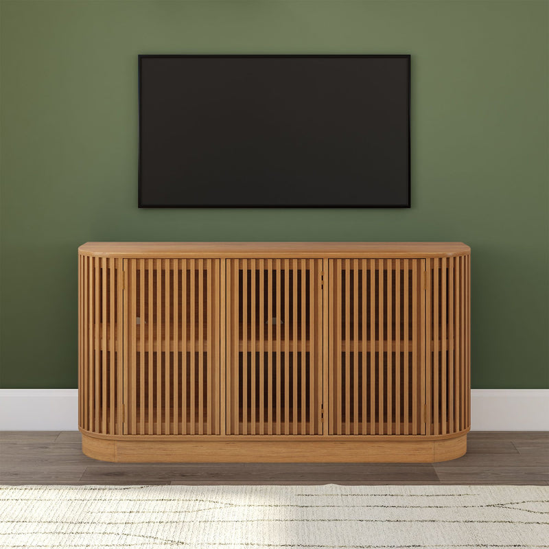 Mid-century modern natural oak slatted media console TV stand with rounded corners beneath wall-mounted flat-screen TV on green accent wall in living room