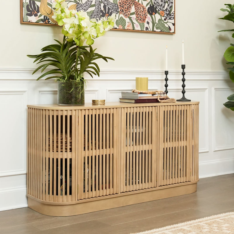 Modern wooden sideboard with vertical slats, decorated with potted plant, candles, and books, in a stylish living room.