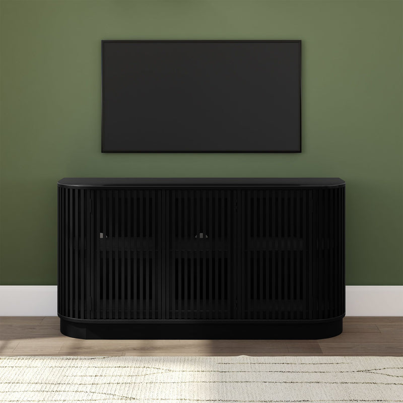 Modern black slatted media console with wall-mounted flat-screen TV on sage green wall, hardwood floor and neutral area rug, minimalist entertainment center