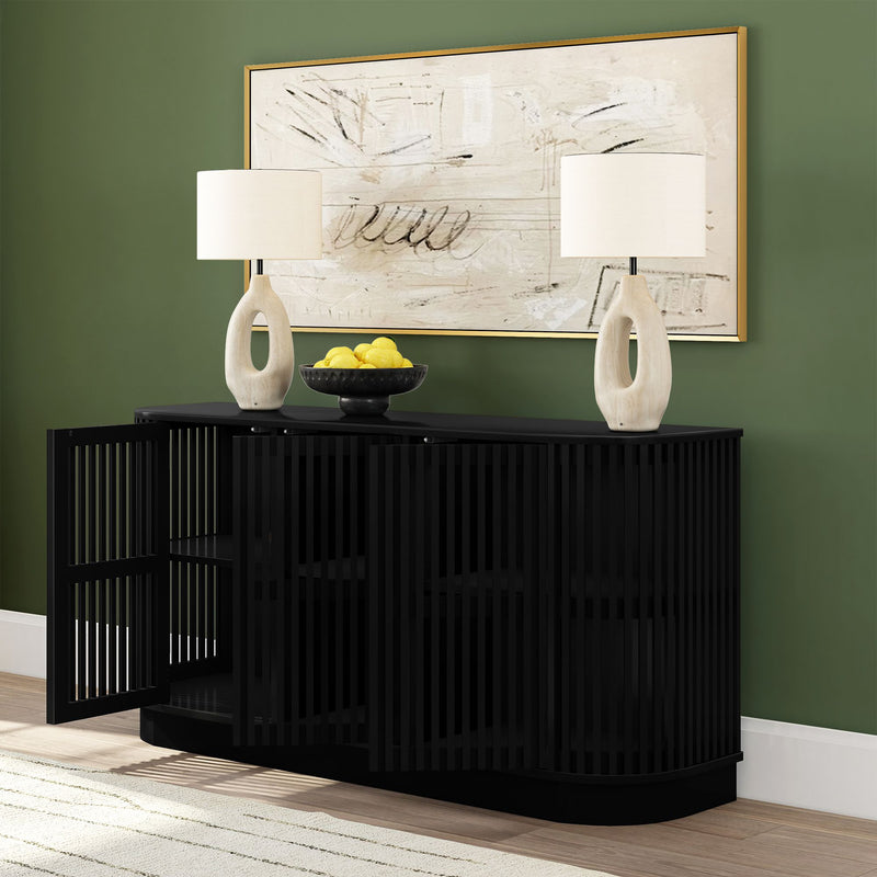 Modern black slatted console table in entryway with one door open, two ceramic loop table lamps, bowl of lemons and abstract framed art on green accent wall