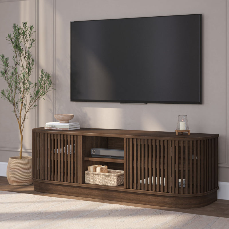 Modern living room with a flat-screen TV mounted above a chic wooden media console and decorative accents.
