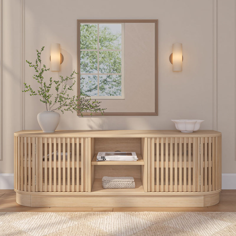 Modern wooden sideboard with slatted design, accompanied by a vase of green branches and a decorative bowl, in a stylish neutral-colored living room setting.