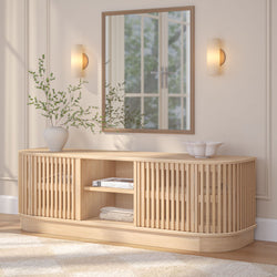 Modern wooden sideboard with decorative vase, mirror, and soft lighting in elegant living room setting.