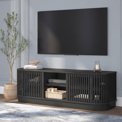 Stylish black entertainment center with modern TV setup in living room featuring decorative plants and accessories.
