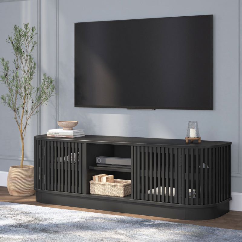 Stylish black entertainment center with modern TV setup in living room featuring decorative plants and accessories.